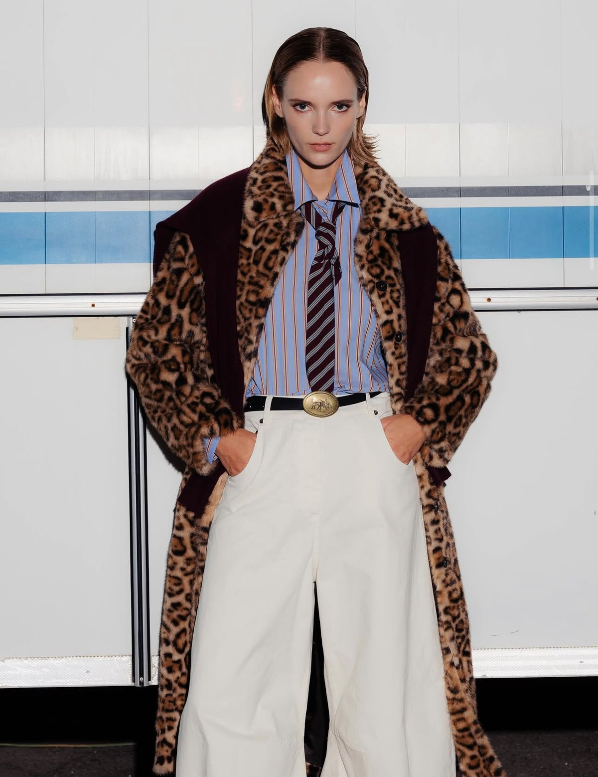Cappotto leopardato con camicia a righe e pantaloni bianchi